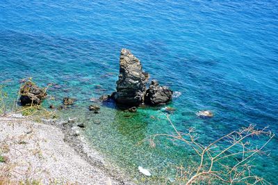 High angle view of rock formation in sea against sky