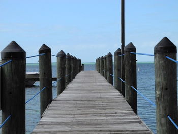 Wooden pier on sea against sky