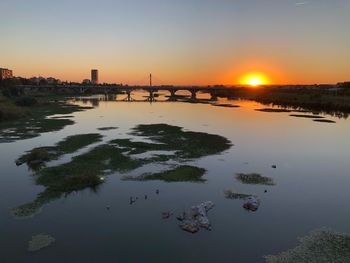 Scenic view of river against sky during sunset