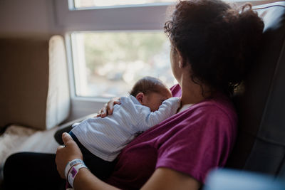 Woman sitting with newborn son at home