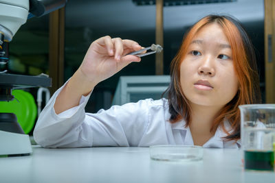 Little scientists analyze the composition of a stone or rock sample in laboratory. science 