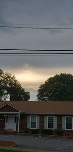 Houses and trees against sky at dusk