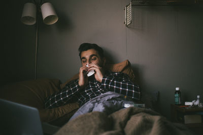 Young man sitting on sofa at home