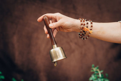 Cropped hands of person holding musical equipment outdoors