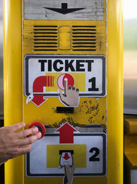 Low section of person holding yellow sign on bus