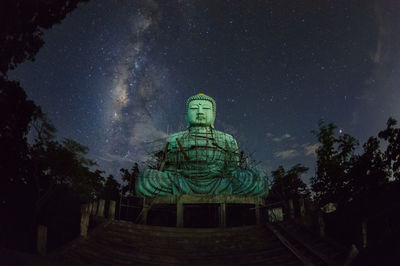 Daibutsu or 'giant buddha' large statue of buddha, with milky way moving in sky.