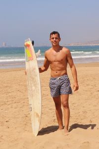 Portrait of shirtless man standing at beach