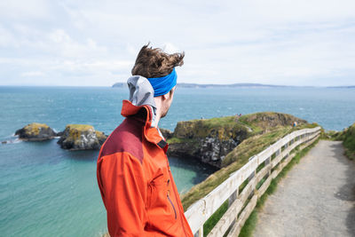 Rear view of woman looking at sea against sky
