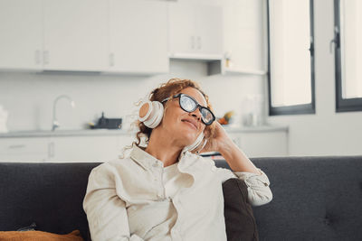 Young woman using mobile phone while sitting at home