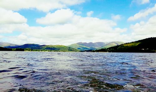 Scenic view of calm lake against cloudy sky