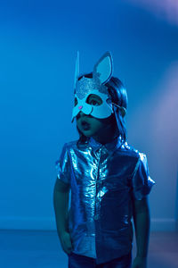 Christmas baby boy in hare mask in studio on blue wall background