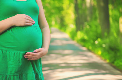 Midsection of pregnant woman on road