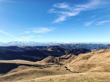 Scenic view of landscape and mountains against blue sky