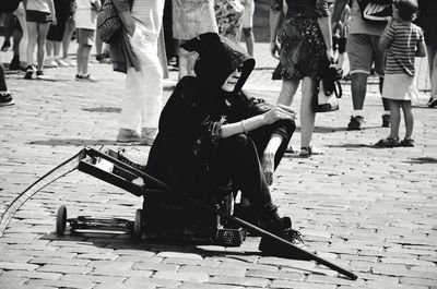 Man sitting on floor in city