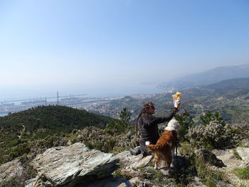 Woman with dog sitting on field