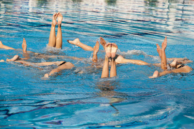 Low section of people swimming in pool