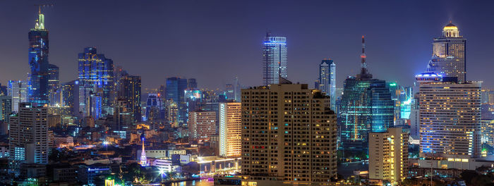 Illuminated buildings in city against sky at night