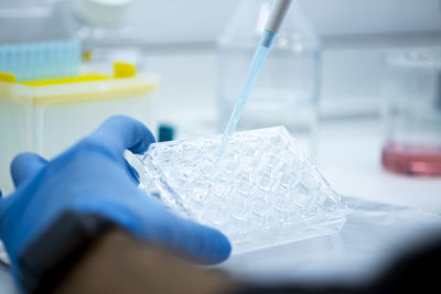 Cropped hand of scientist examining chemical in laboratory