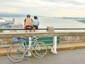 Rear view of man riding bicycle in sea