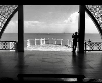 Silhouette people looking at sea against sky