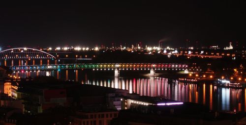 Illuminated cityscape against sky at night