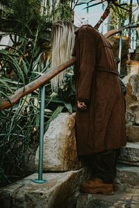 Rear view of woman standing against wall