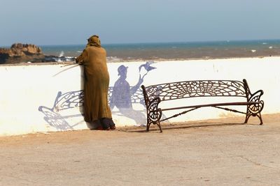 Rear view of man looking at sea shore