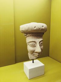 Close-up of statue against yellow wall