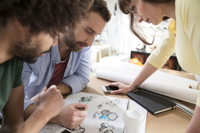 Three colleagues discussing draft in office