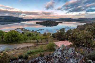 Scenic view of lake by trees against sky