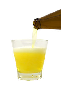 Close-up of yellow pouring over white background