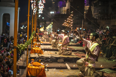 People at illuminated street market in city at night