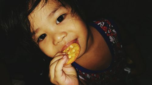 High angle view of little girl eating biscuit