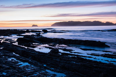 Scenic view of beach against sky during sunset