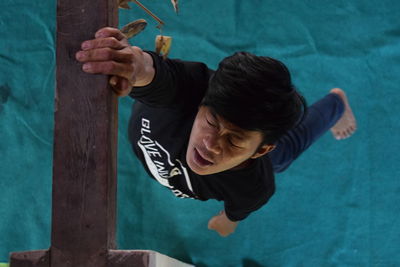 High angle view of man hanging on wood