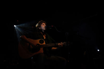 Man playing guitar at night