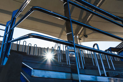 Low angle view of sunlight streaming through railing of building