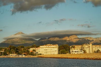 Buildings by sea against sky in city