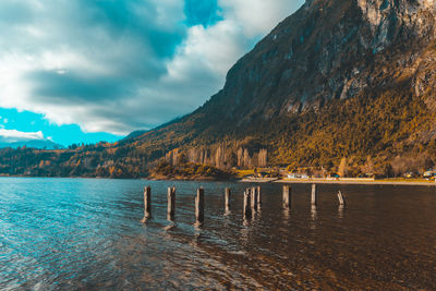 Scenic view of lake by mountains against sky