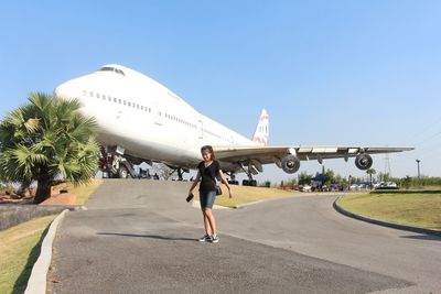 Full length of woman on airport runway against clear sky