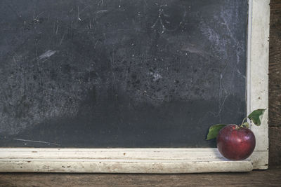 Close-up of apples on table against wall