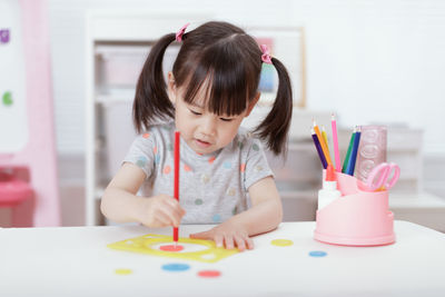 Cute girl sitting on table