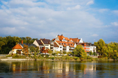 Buildings in town against cloudy sky