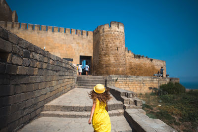 Rear view of man standing against wall