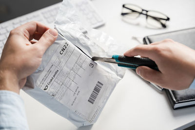 Midsection of man holding paper with text