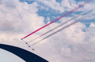 Low angle view of airplanes flying against sky