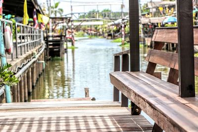 Empty bench on pier by river