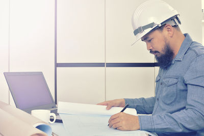 Side view of man working with mobile phone