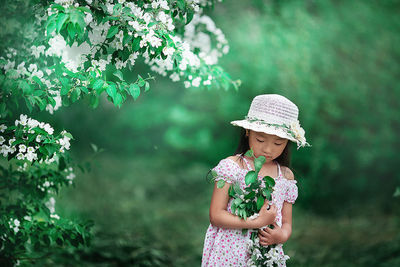 Full length of woman standing by flowering plants