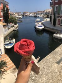 Man holding ice cream cone in canal
